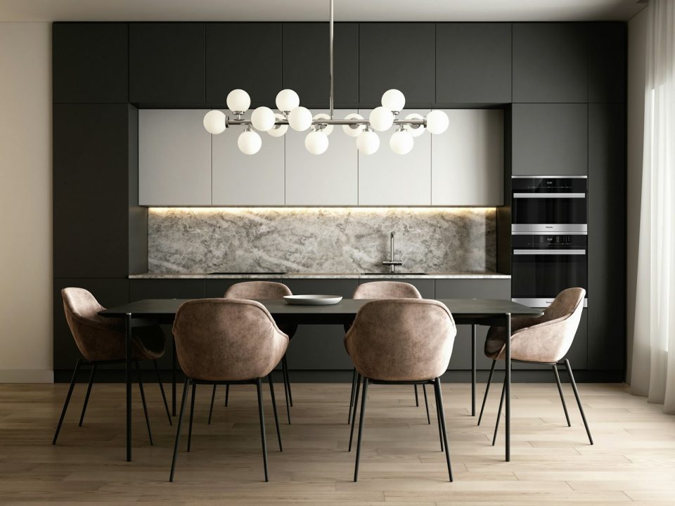 Modern open-plan kitchen and dining interior with dark cabinetry