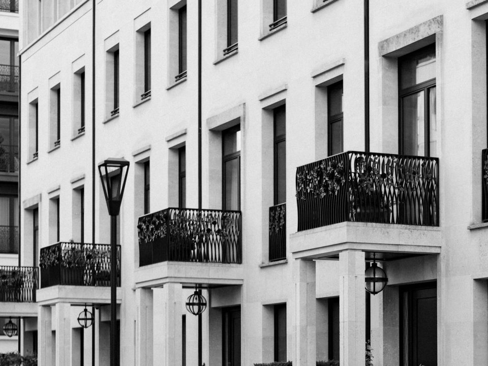 Row of modern multi-unit townhouses with black balconies