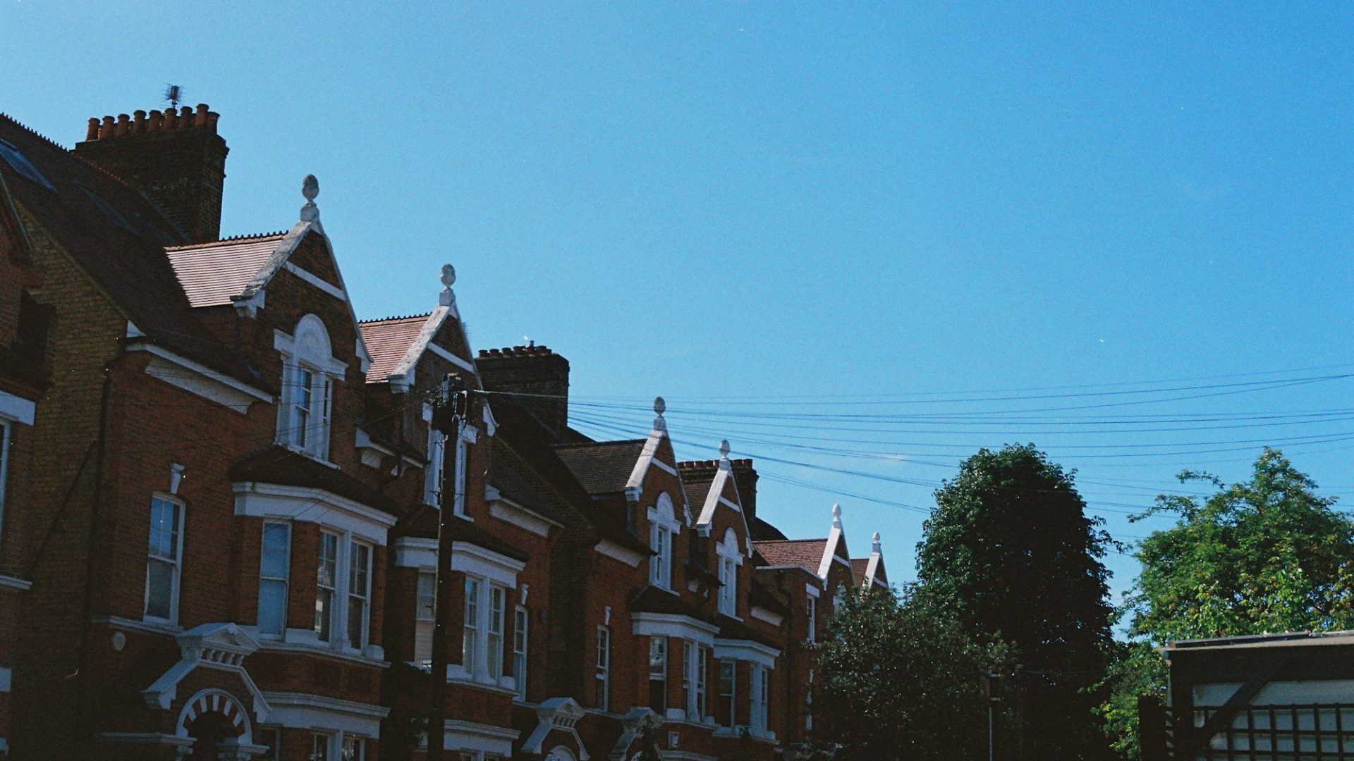 Row of brick terraced houses under a clear sky (illustrative image)