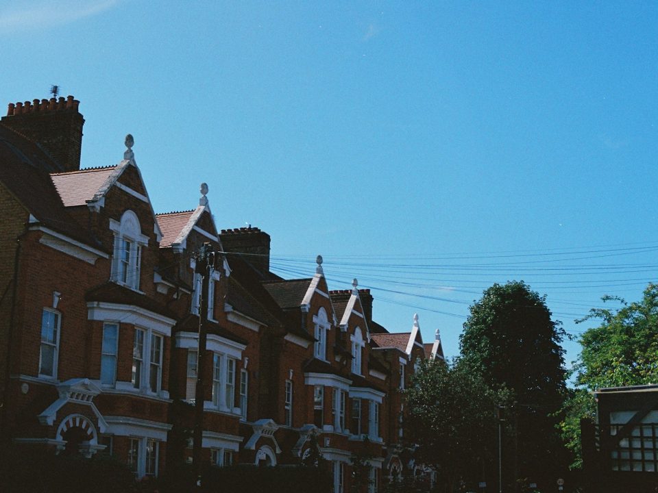 Row of brick terraced houses under a clear sky (illustrative image)